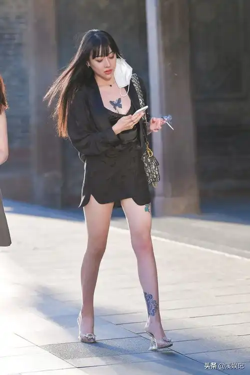 一边吸烟一边看手机的美女,长腿吸睛,纹身霸气,一看就是社会人