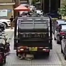 危险女子走路看手机被卷垃圾车底