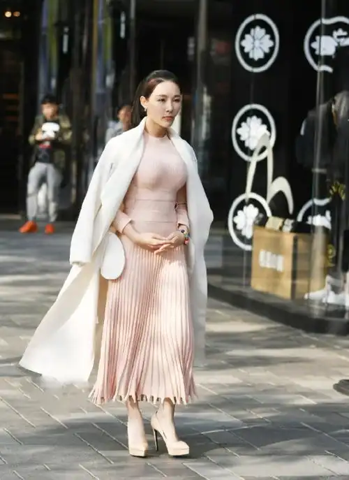 美女一袭粉色连衣裙搭配白色外套,霸气而不失性感,尽显傲人身材