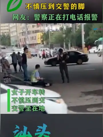 女子开车转弯不慎压到交警的脚交警坐在地上似乎很痛的样子