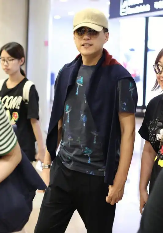 靳东又穿这件马甲走机场,这次内搭深色t恤,有男人味多了