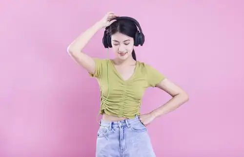 粉色背景里戴着耳机的亚洲美女,女性女人,人物百态,摄影素材,汇图网