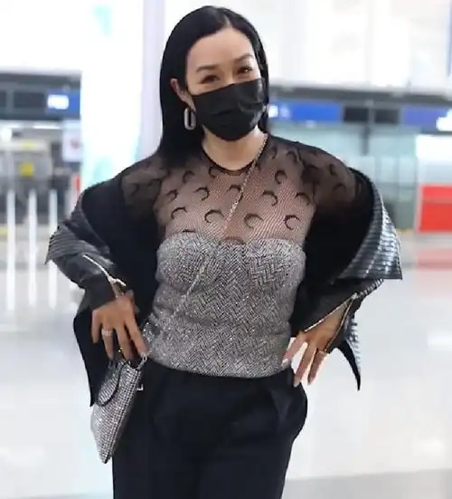 50岁钟丽缇走机场,谁留意到她手中的水杯,少女心藏不住啊