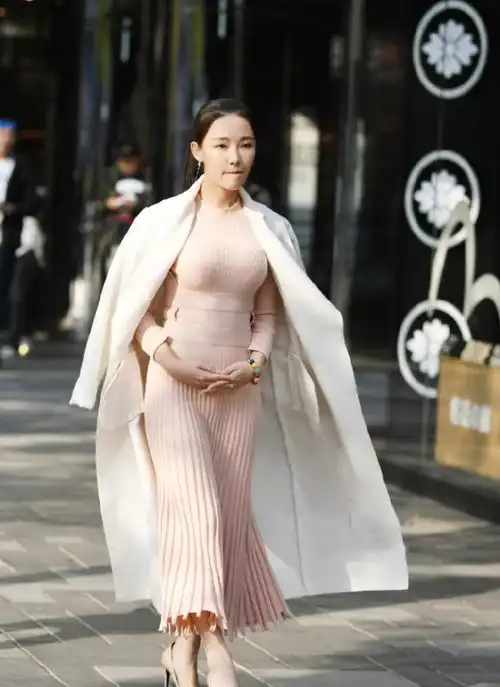 美女一袭粉色连衣裙搭配白色外套,霸气而不失性感,尽显傲人身材