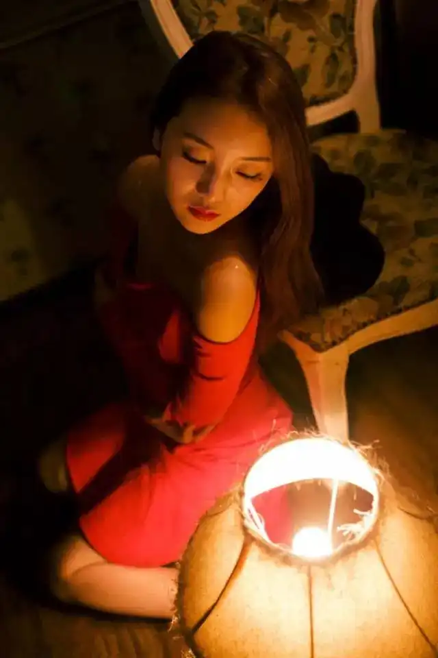 昏暗灯光下鲜花美女香肩红裙娇艳彰显别样风情