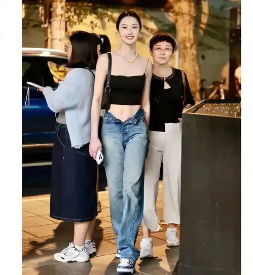 这女孩真漂亮,穿的还挺时髦,牛仔裤没扣纽扣走着会不会掉下来