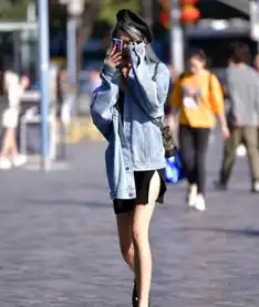 街拍温柔可人的美女,一件拼接上衣配黑色短裤,时尚优雅迷人