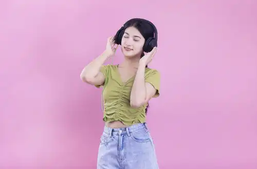 粉色背景里戴着耳机的亚洲美女,女性女人,人物百态,摄影素材,汇图网