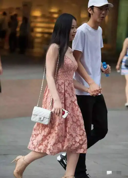美丽的连衣裙姑娘,挽着男朋友的手走在街上是一件幸福的事