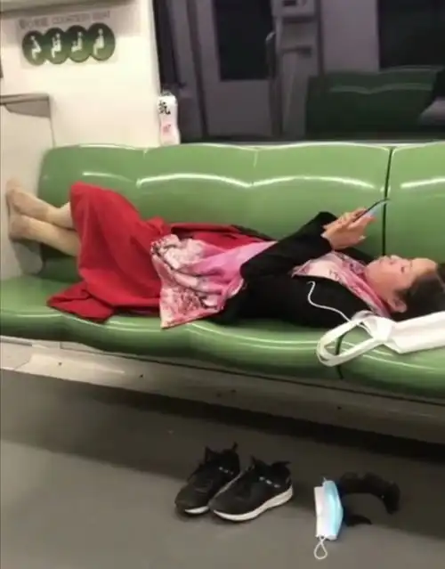 上海地铁一女子脱鞋摘口罩躺在爱心专座玩手机抠牙,一人占四座